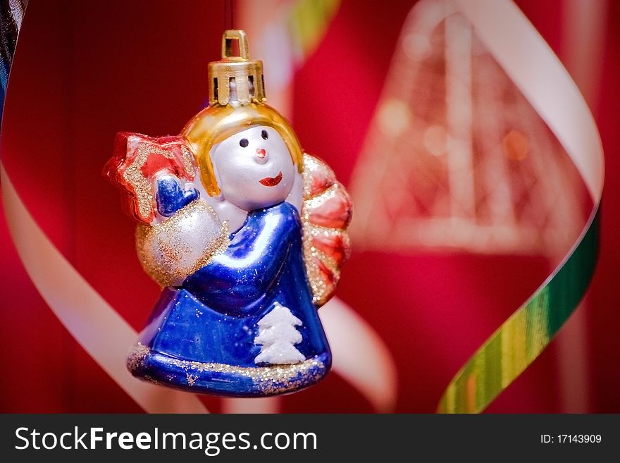 Christmas angel (christmas-tree decoration) hangs. Red background