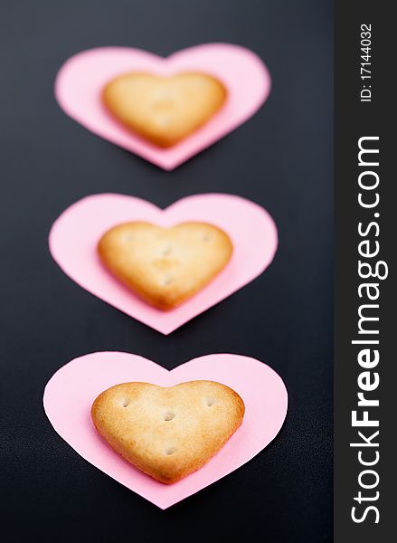 Three crackers on pink paper hearts