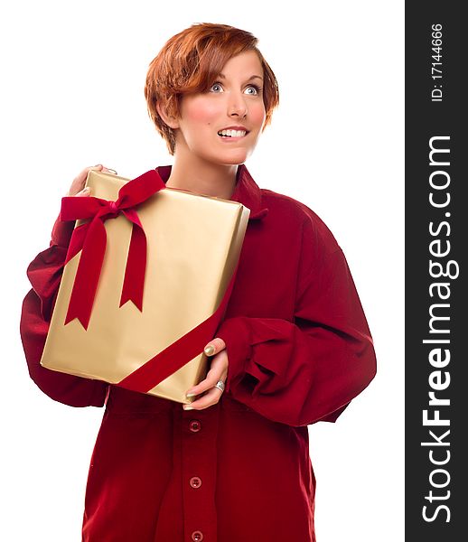 Pretty Red Haired Girl Biting Her Lip Holding Wrapped Gift Isolated on a White Background. Pretty Red Haired Girl Biting Her Lip Holding Wrapped Gift Isolated on a White Background.