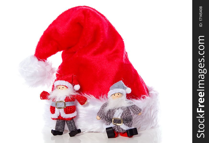 Two santa claus in front of a christmas hat isolated over white. Two santa claus in front of a christmas hat isolated over white