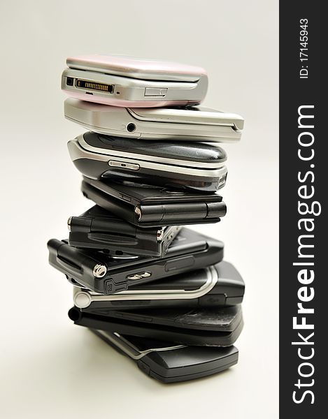 Stack of assorted cellphones on white background. Stack of assorted cellphones on white background