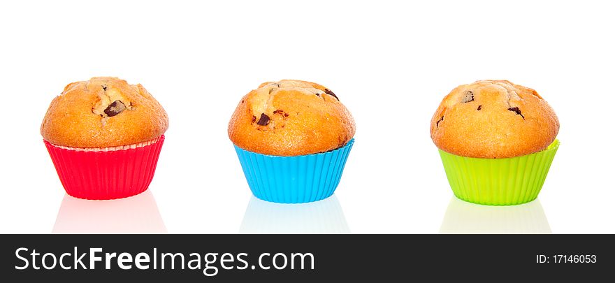 Three muffins with chocolate abreast in colorful cupcake-molds  isolated over white