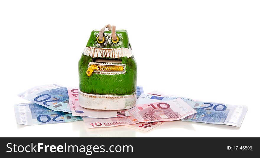 A green money-box on top of euro banknotes isolated over white. A green money-box on top of euro banknotes isolated over white