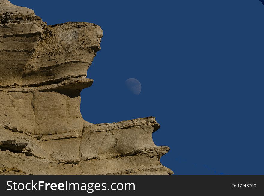 Limestone hill in Zakynthos, Greece against the clear blue sky and the Moon. Limestone hill in Zakynthos, Greece against the clear blue sky and the Moon