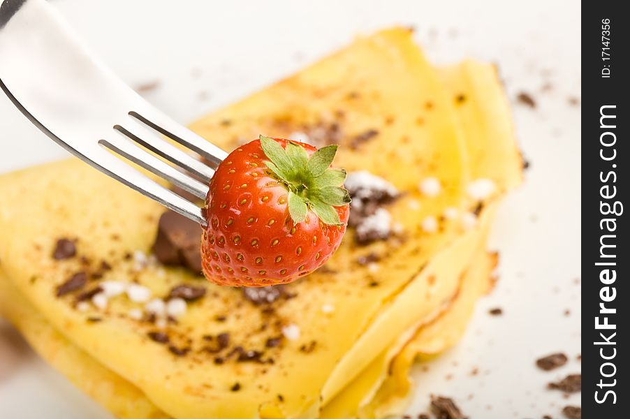 Photo of crepes with choccolate and strawberries on a white plate