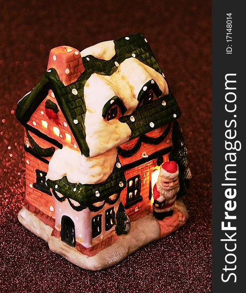 Little toy house with Santa Claus and candle in