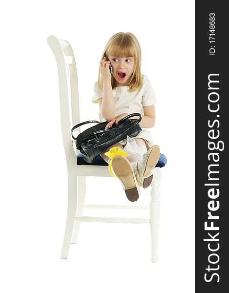 Surprised girl with phone on chair isolated in white