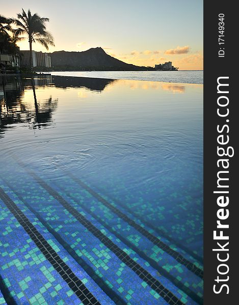 An infinity pool steps reflect Diamond Head at sunrise. An infinity pool steps reflect Diamond Head at sunrise