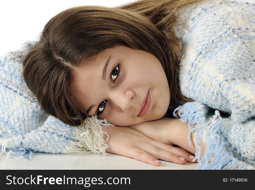 A beautiful young teen laying on her hands, surrounded by a pale blue and white poncho. A beautiful young teen laying on her hands, surrounded by a pale blue and white poncho.