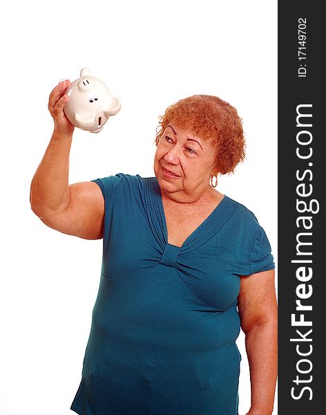 Hispanic female senior shaking piggy bank. Hispanic female senior shaking piggy bank