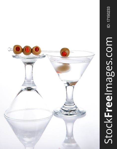 Two martini glasses with green olives isolated on a white background. Two martini glasses with green olives isolated on a white background