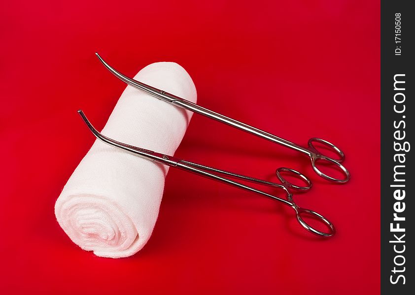 Bandage with a surgical instrument on a red background
