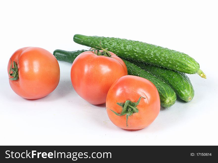Tomatoes and cucumbers on white background. Tomatoes and cucumbers on white background