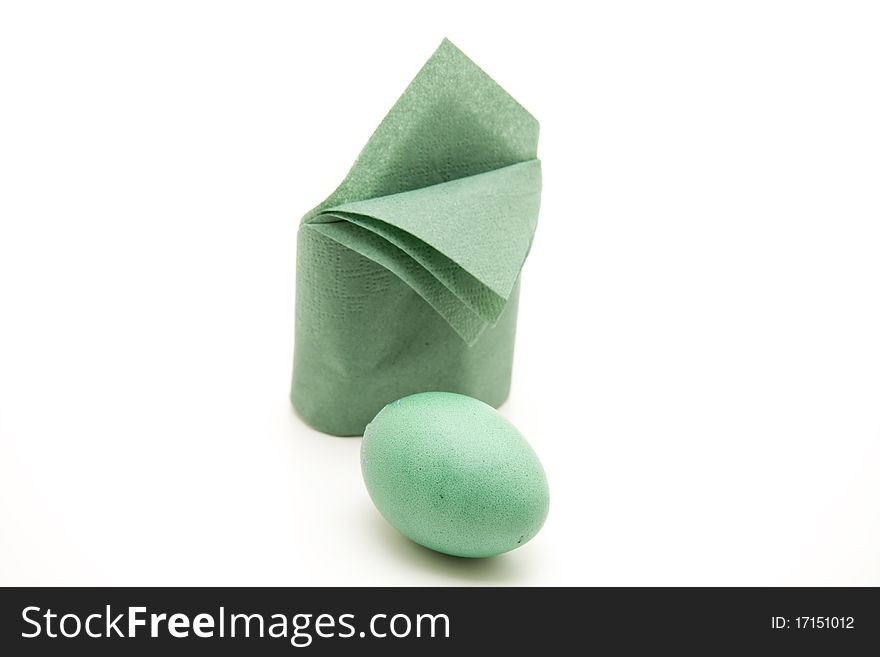 Green Easter egg before greener folded napkin. Green Easter egg before greener folded napkin