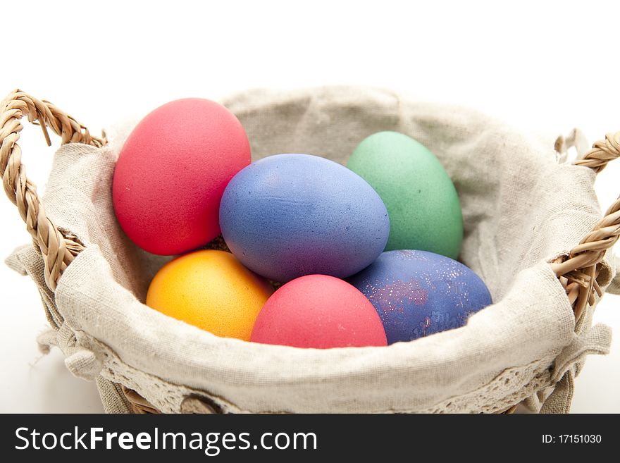 Colored eggs in the basket with material