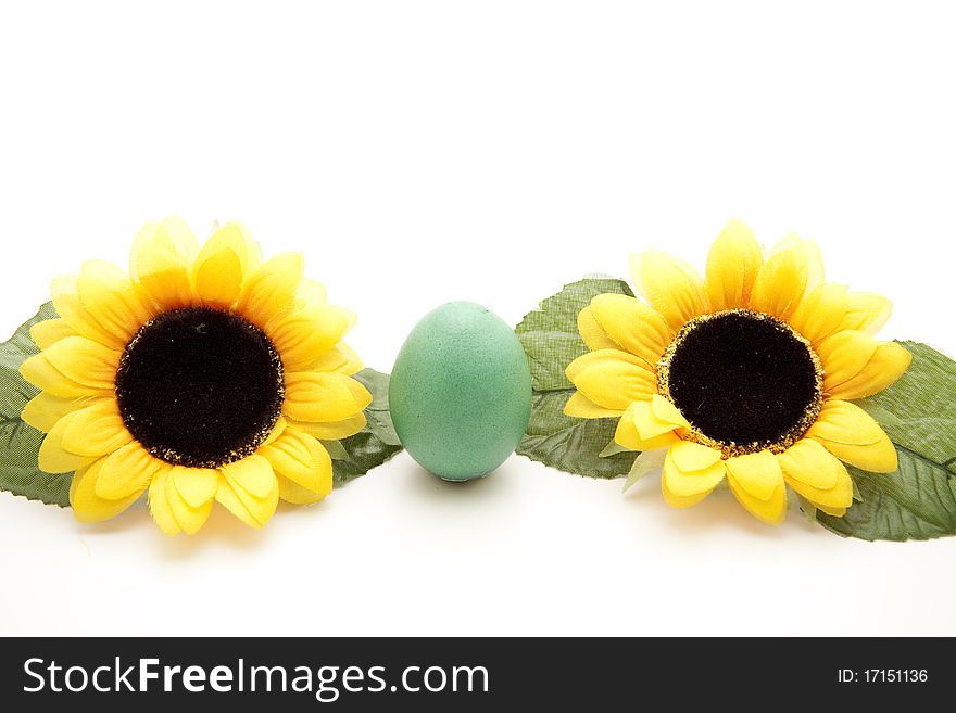 Green Easter egg between sunflowers