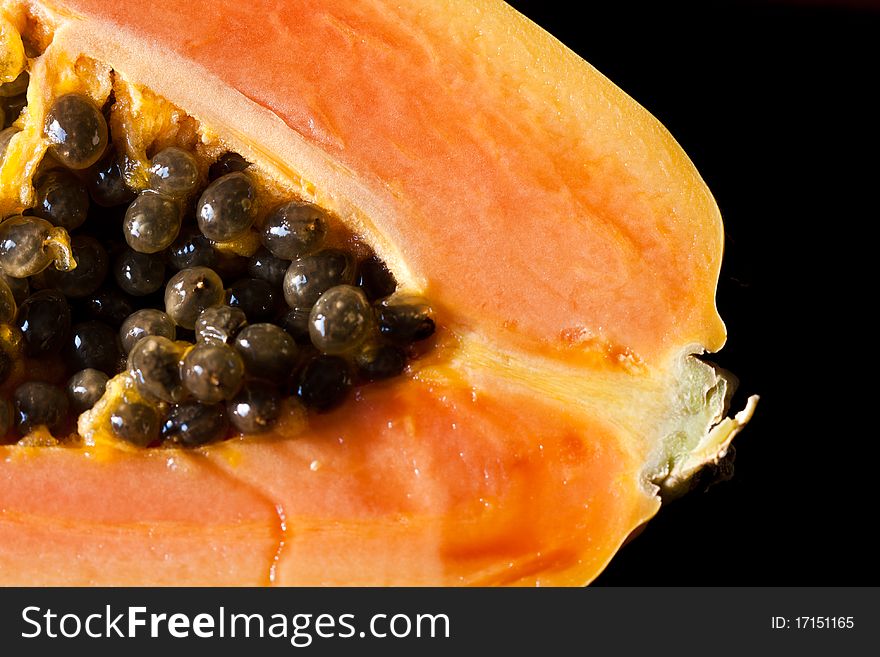 A close-up image of a papaya and its seeds. A close-up image of a papaya and its seeds