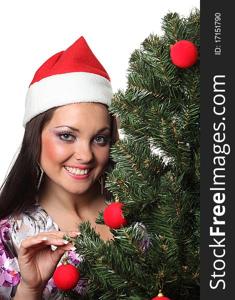 Woman in a christmas hat decorate a christmas tree. Woman in a christmas hat decorate a christmas tree