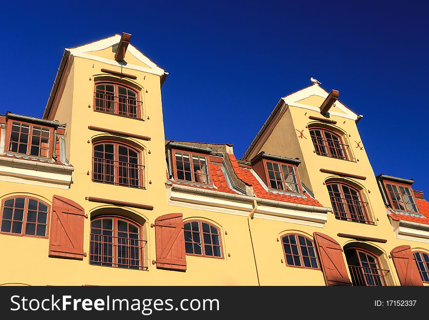 Traditional mustard colour office warehouse against a bright blue sky. Traditional mustard colour office warehouse against a bright blue sky