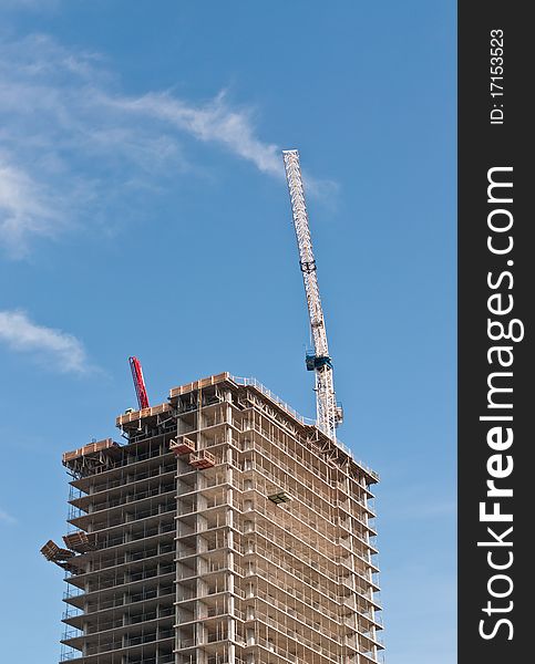 A high rise building under construction with tower crane.