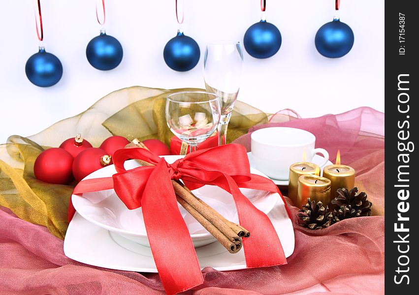 Christmas tableware, decorated with cinnamon sticks, ribbon, christmas balls, candles and cones. Christmas tableware, decorated with cinnamon sticks, ribbon, christmas balls, candles and cones