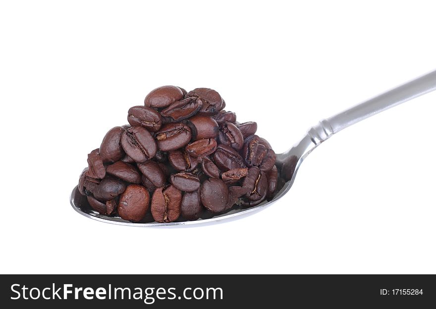 Heaping spoonful of coffee beans isolated on white