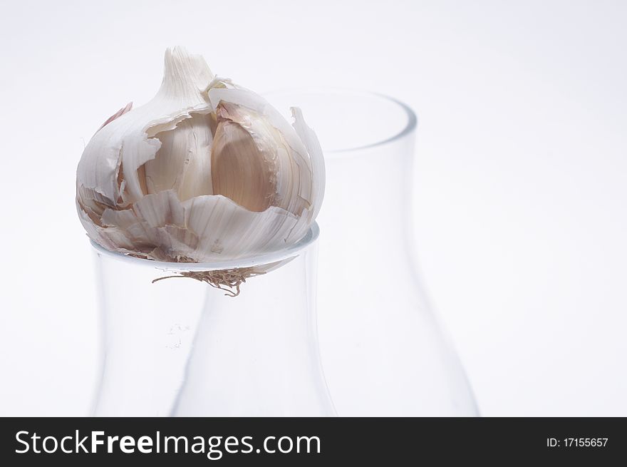 Garlic in a glass on light background. Garlic in a glass on light background