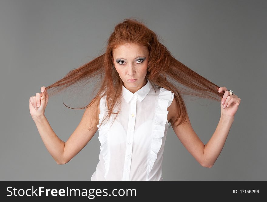 Young beautiful redhead woman. Gray background