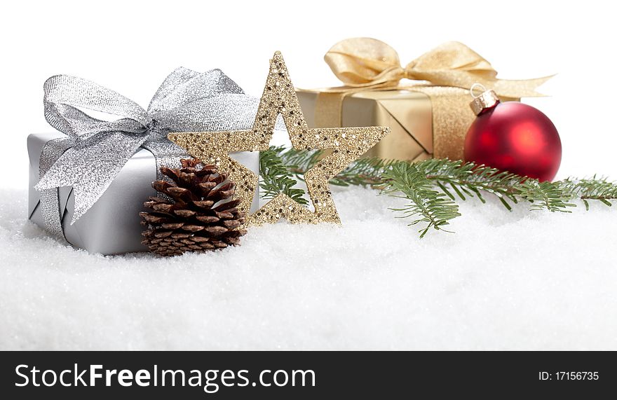 Christmas Present are lying with a branch and a bauble in snow