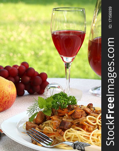 Spaghetti bolognese, wine and fruits on a dinner table. Spaghetti bolognese, wine and fruits on a dinner table.