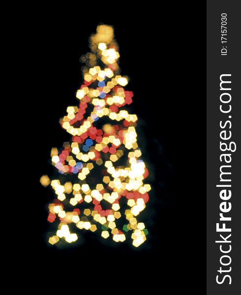 Blurred Christmas tree lights isolated over black.