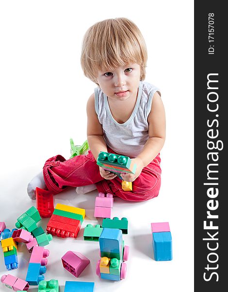 Little boy playing with colorful blocks, studio shot, high angle view