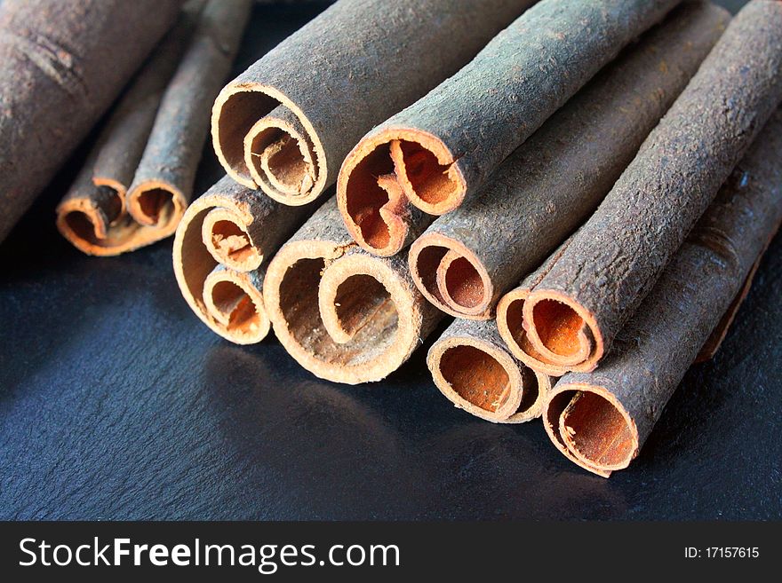 Pile of cinnamon sticks showing their cut and curled edges.