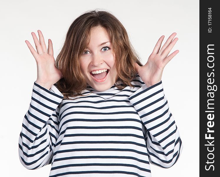 A portrait of the pretty surprised girl in the stripped black and white sweater on a white background. A portrait of the pretty surprised girl in the stripped black and white sweater on a white background