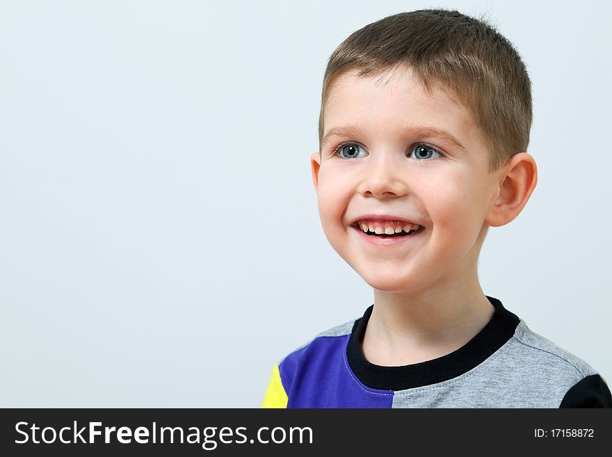 Close up portrait of smiling cute little boy on background