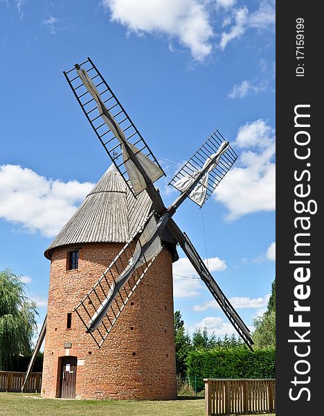 Old renovated windmill with blue sky background
