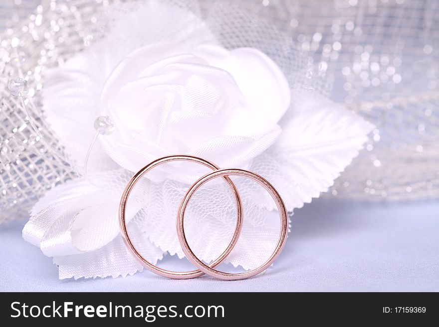 Wedding rings and white satin flower