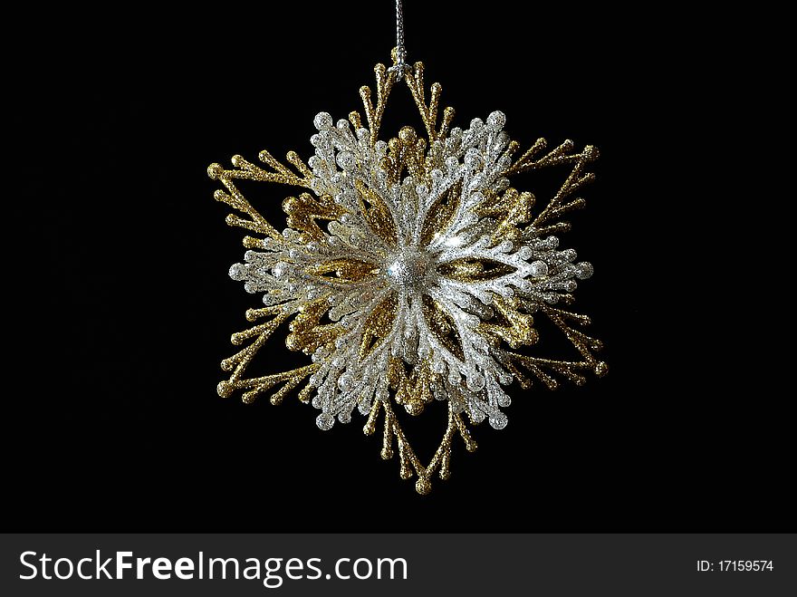 Silver-golden snowflake on a black background. Silver-golden snowflake on a black background.