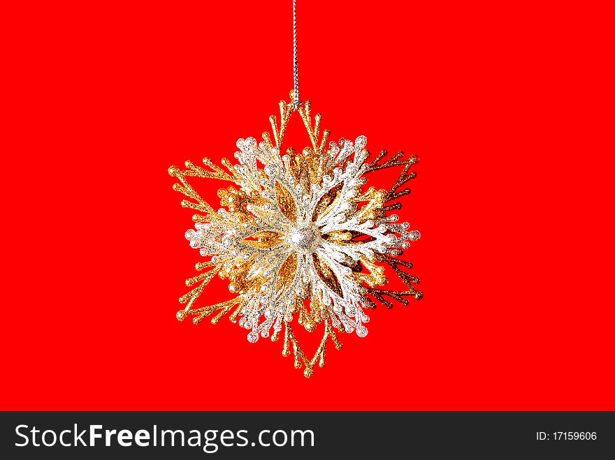 Silver-golden snowflake on a pure red background. Silver-golden snowflake on a pure red background.