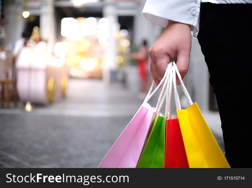 Asian girls holding sale shopping bags. consumerism lifestyle concept in the shopping mall.