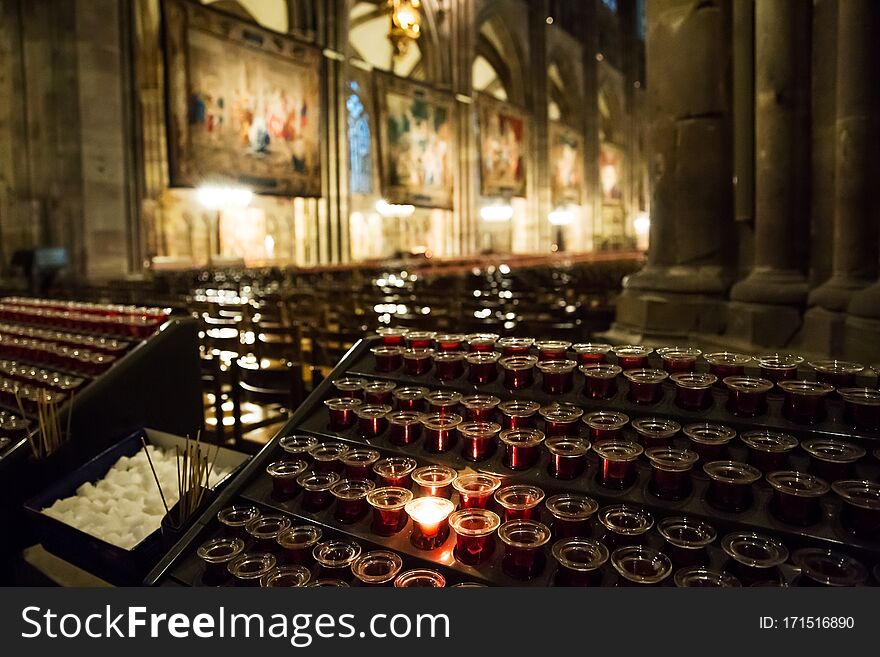 Lighting candles in a catholic temple . Candles are lit near the altar in a Catholic temple