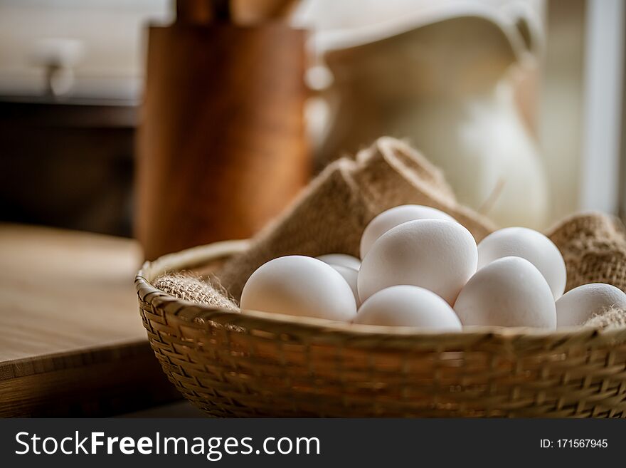 Chicken eggs in basket on table.