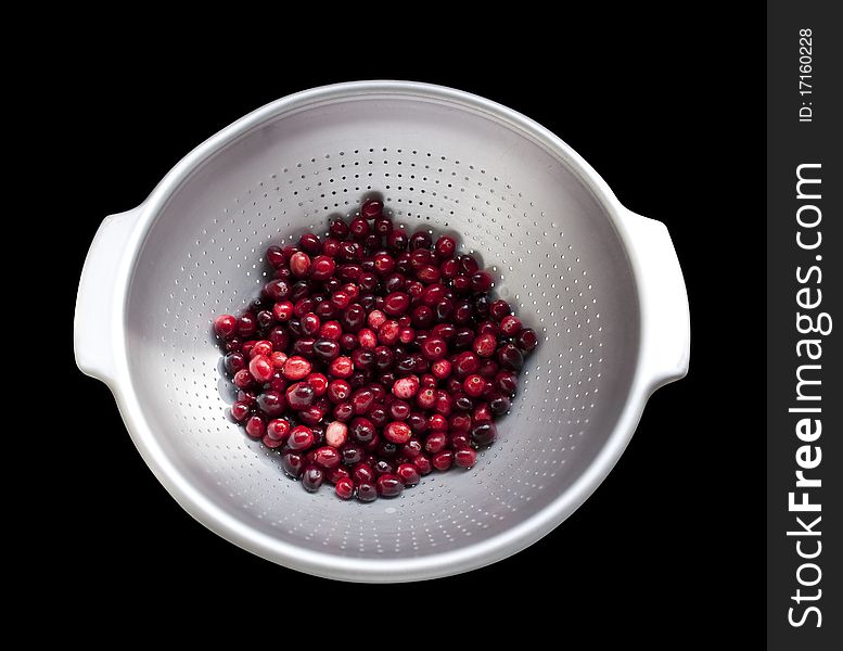 Cranberries about to be washed in colander on black, isolated with clipping path. Cranberries about to be washed in colander on black, isolated with clipping path