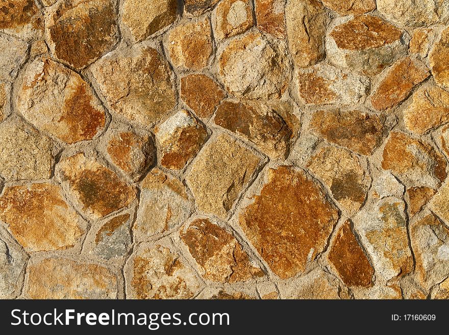 Close up of an orange tinted stone wall background