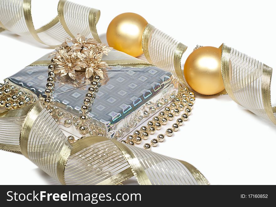 Beautifully wrapped gift box with gold flowers and ribbons on a white background