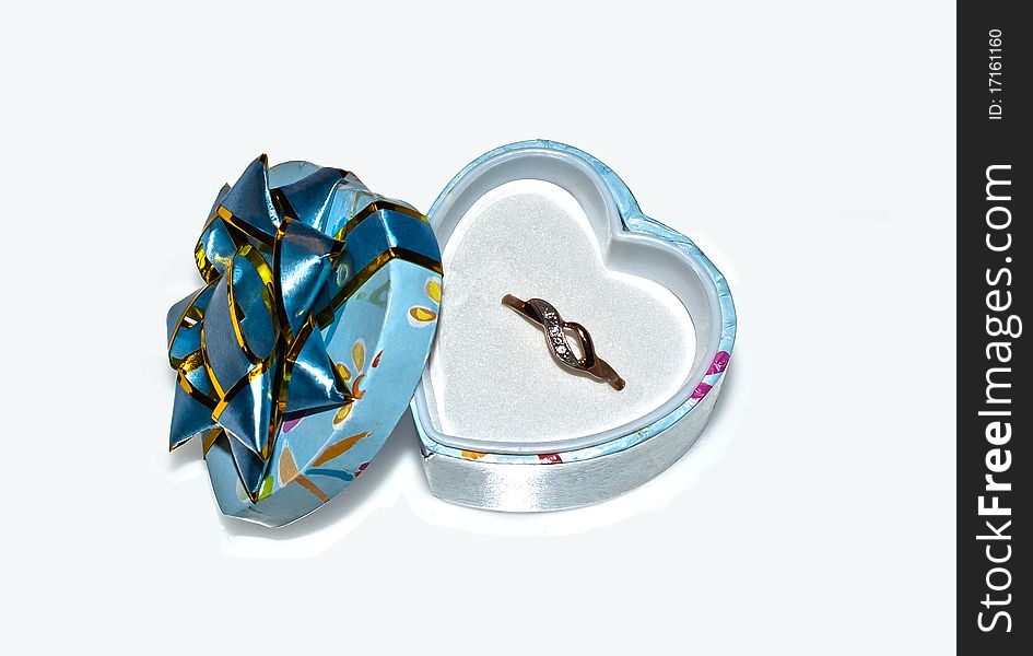 A golden ring in a heart-shaped box. A golden ring in a heart-shaped box