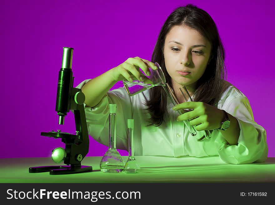 Young school girl playing with tubes and a microscope. Young school girl playing with tubes and a microscope
