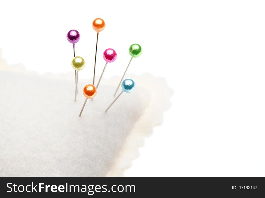 Pins and pincushion isolated on white background