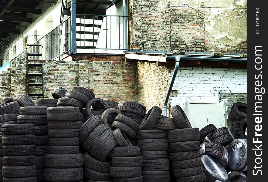 Wall of old car tires with old Brick Wall in the background