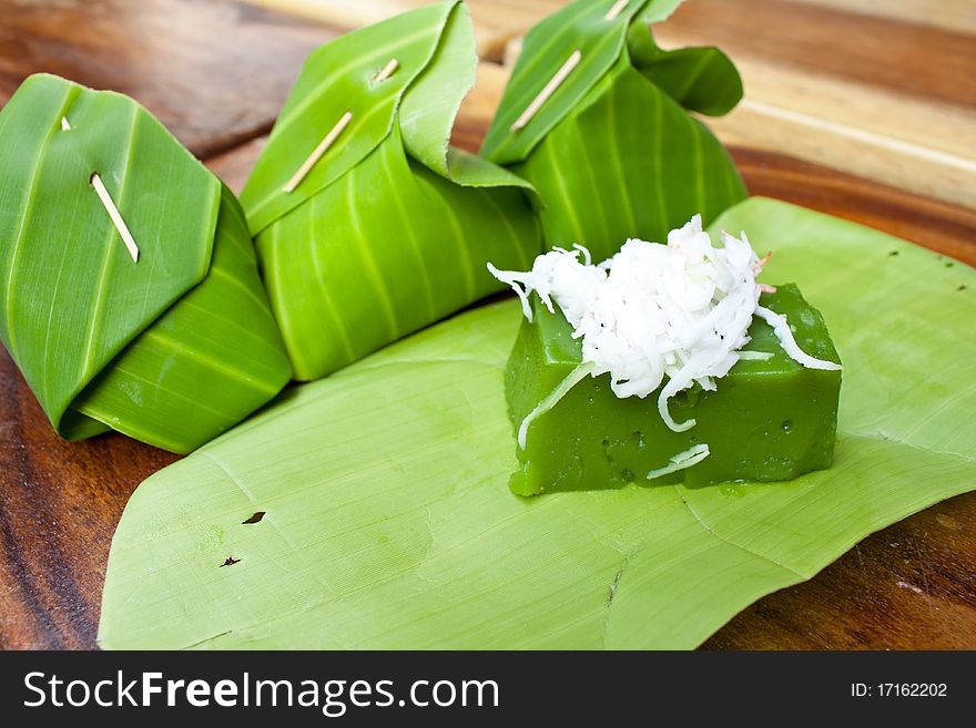 Green sweet pudding call Kanom Peakpoon made of Pandanus leaf flavor and coconut and banana leaf as it's packages. Green sweet pudding call Kanom Peakpoon made of Pandanus leaf flavor and coconut and banana leaf as it's packages